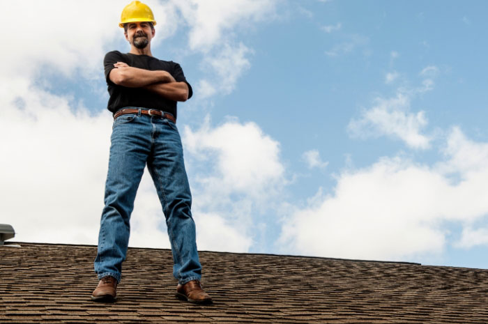 construction boss standing on top of a residential roof