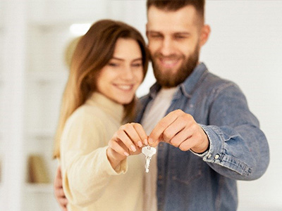 new homeowners, a young couple, holding house keys
