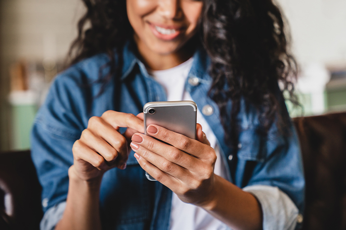 woman tapping her cell phone screen