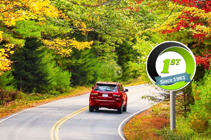 red car drives on road in Fall