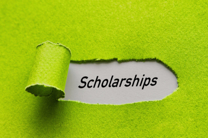 peeled away lime green paper covering to reveal the word Scholarships