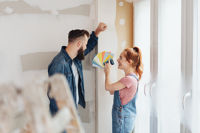 Young couple picking out paint colors for wall