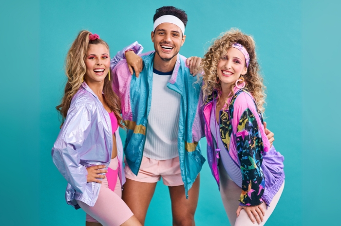 A trio of adults dressed in vintage neon 80's-style workout clothes